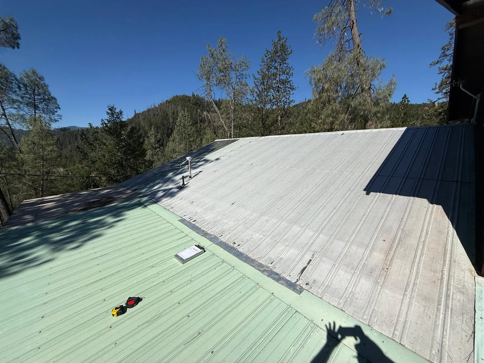 Before: Old corrugated metal to charcoal standing seam, with new skylights