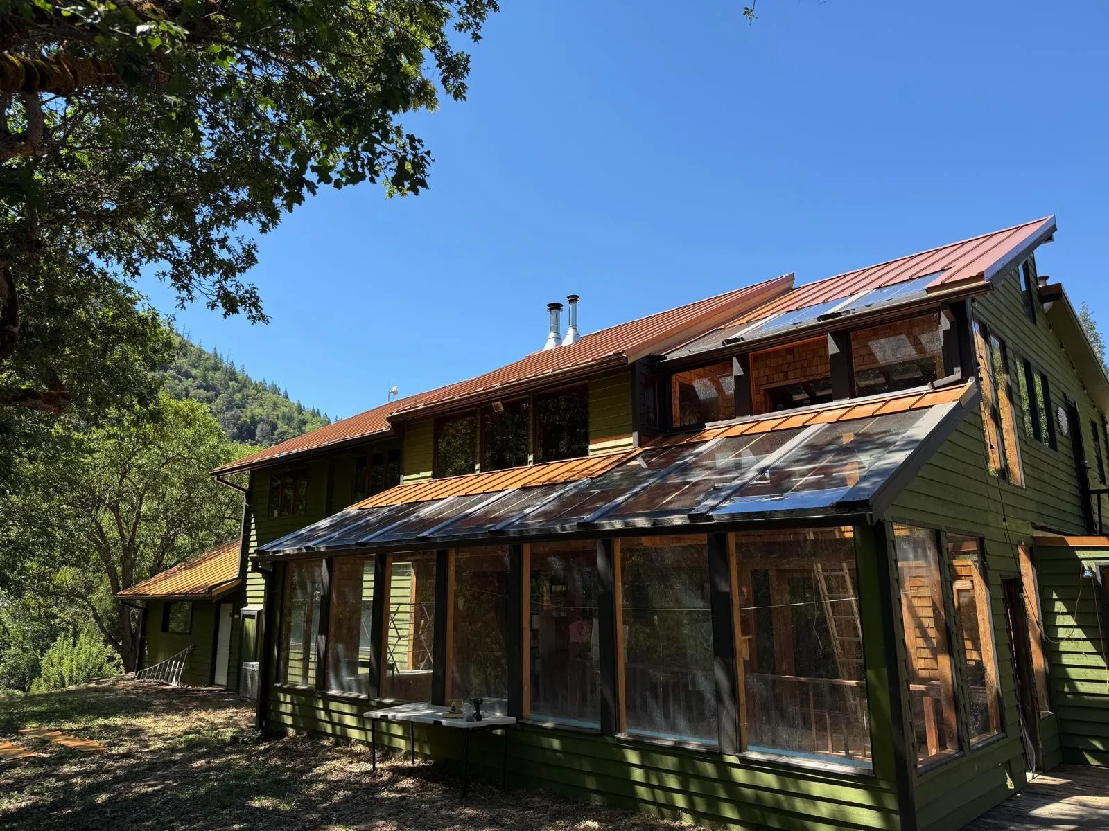 After: Copper-colored standing seam metal roof on a hillside home