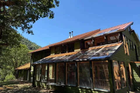 Copper-colored standing seam metal roof on a hillside home