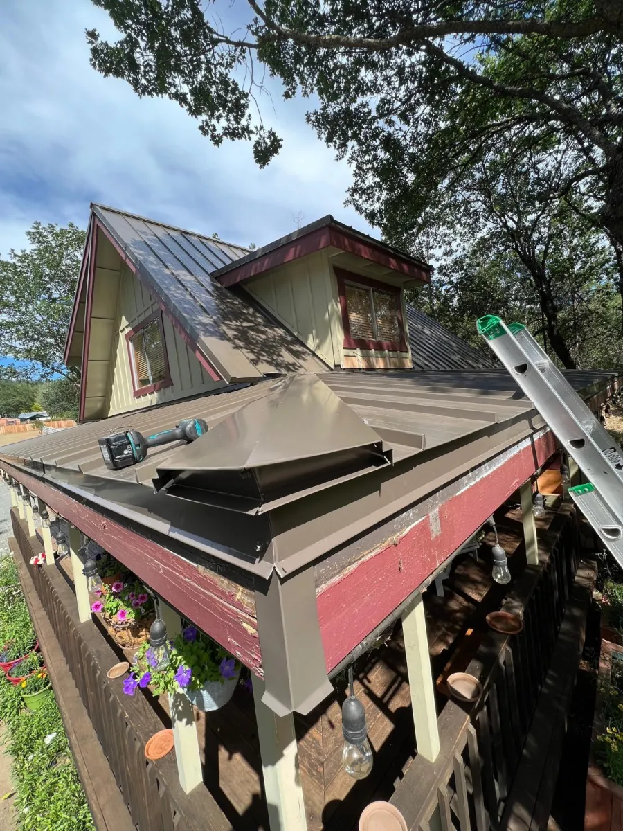 After: Bronze metal roof on a home with red trim