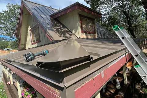 Bronze metal roof on a home with red trim