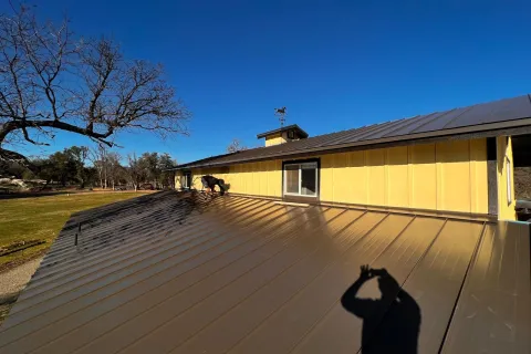 Yellow building with a dark standing seam roof