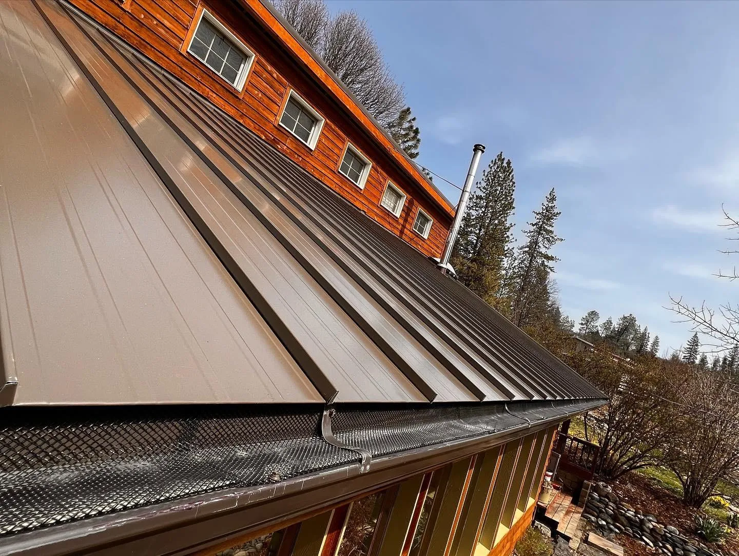 After: Standing seam metal roof with gutter guards